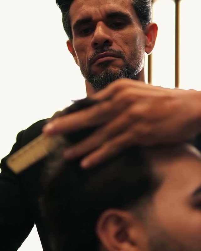 Close do barbeiro finalizando o corte