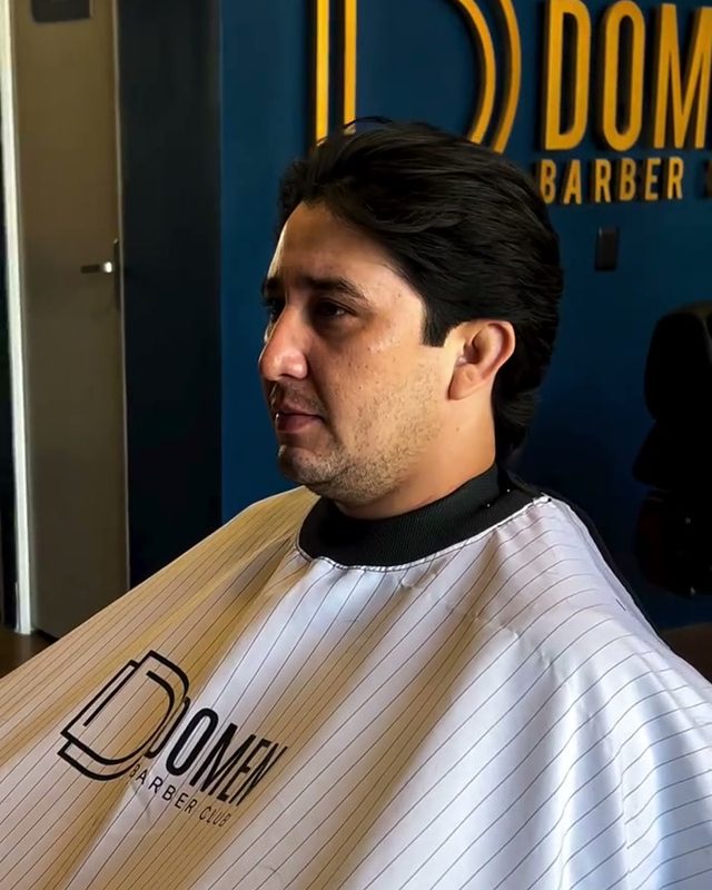 Cliente com a capa da Domen no salão azul